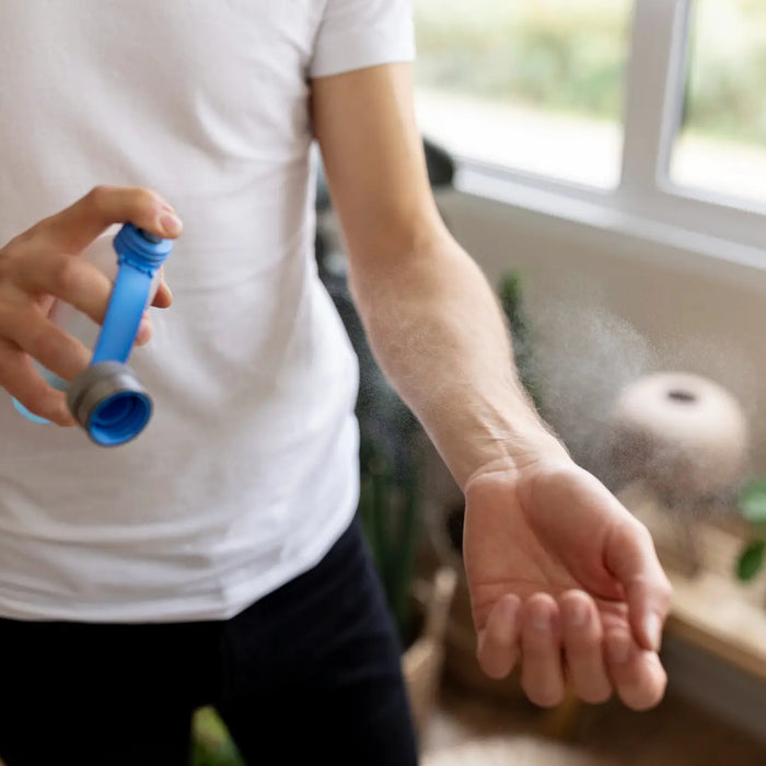 Image of a person applying mosquito spray to avoid dengue