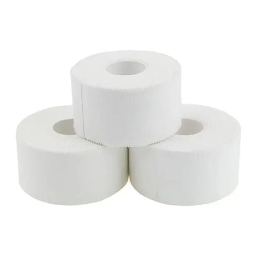 Three rolls of white sticking plaster stacked on a white background